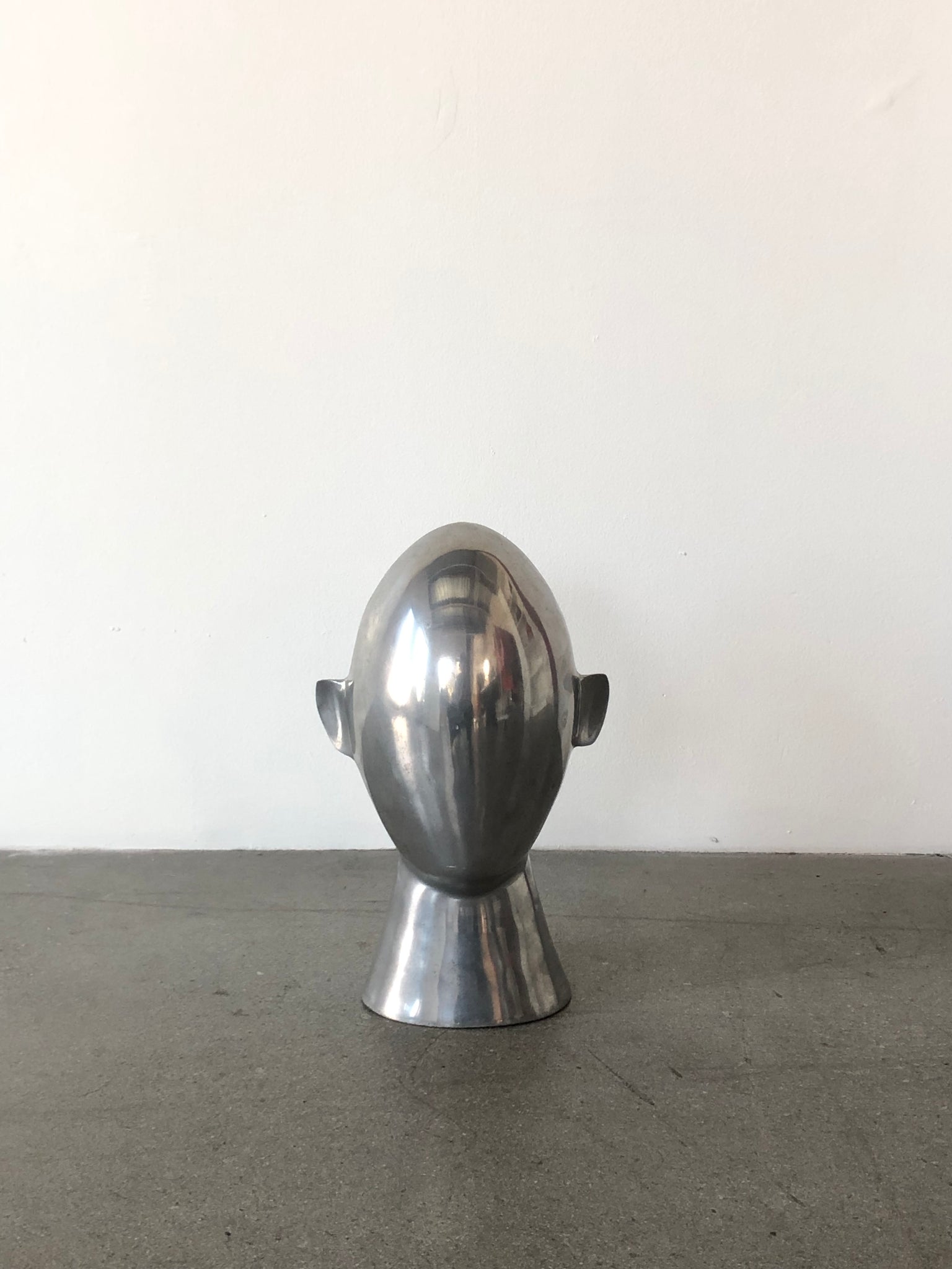 Chrome Brancusi-esque faceless head sculpture